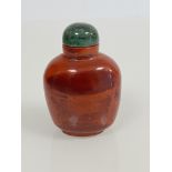 A Chinese red banded agate snuff bottle, with green hardstone stopper. 7cm