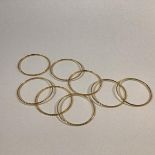 A set of eight Indian yellow metal bangles, each with a chevron pattern, unmarked, probably high