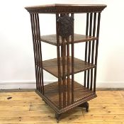 An Edwardian oak revolving bookcase, the rectangular top with dentil frieze above three tiers, on