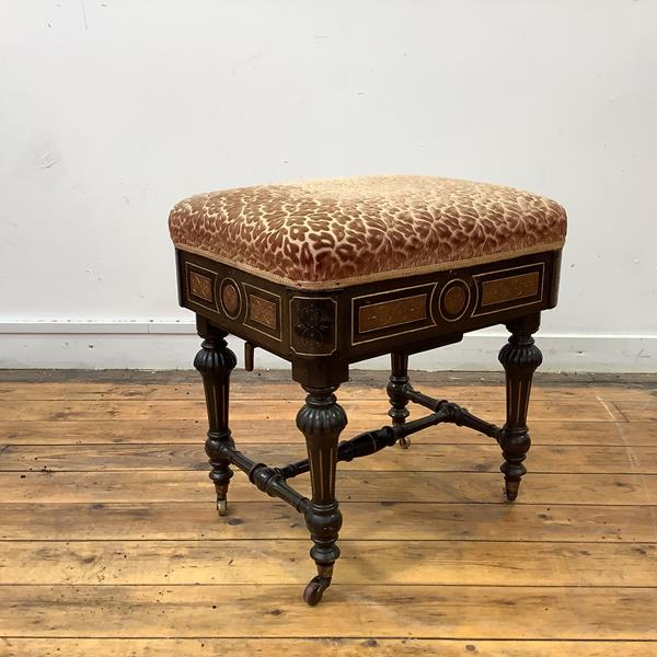 A late 19th century ebonised adjustable piano stool, the padded seat with cut-velvet upholstery,