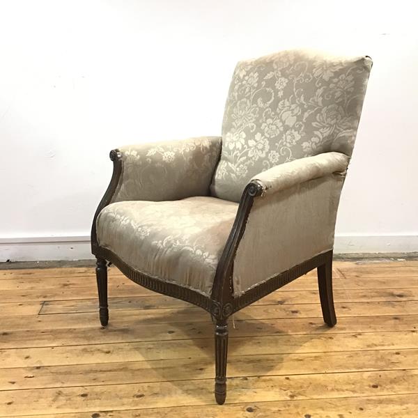 An early 19th century French armchair, the padded back and seat within channel moulded terminals