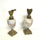 A pair of gilt metal mounted milk glass ewers with the mask spouts and bodies with applied floral