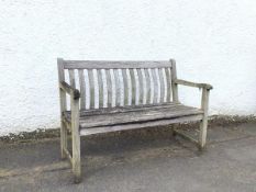 An attractively well weathered rustic oak garden bench, the moulded top rail over bowed back