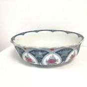 An early 20thc. Wilkinson Burslem wash basin, with slightly scalloped edge and floral decoration (