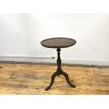 A reproduction mahogany wine table in the George III style, the circular top with piecrust moulded