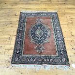 A hand knotted wool North West Persian rug, the fawn field enclosing a floral medallion within