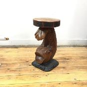 A carved and painted hardwood stool, the circular top with incised frieze, supported by a leaping