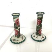 A pair of Wemyss ware style pottery candlesticks of tapered form with green decorated borders and