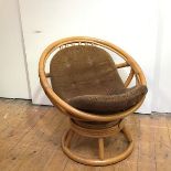 A 1970s bamboo swivel chair, the circular frame bound with reeds enclosing a corduroy buttoned seat,