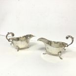 Two similar 1930s silver sauceboats, both with C scroll handles with shell knees and ending in