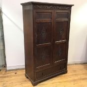 An early 20thc oak hall cabinet, of 17thc design, the projecting cornice above a frieze carved