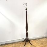 A 1920s mahogany floor lamp, the fluted baluster shaped shaft raised on quadripartite base (h.