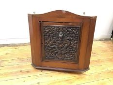 An intricately carved Chinese hardwood panel depicting a dragon emerging from the sea against a