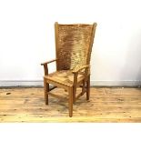 An oak framed Orkney chair, the woven straw back within angled supports above a quarter woven