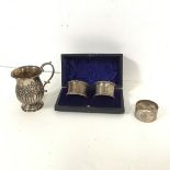 An Edwardian silver mug (h.9cm x d.6cm) (114.42g), an Edinburgh silver napkin ring and two Sheffield