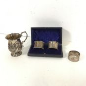 An Edwardian silver mug (h.9cm x d.6cm) (114.42g), an Edinburgh silver napkin ring and two Sheffield