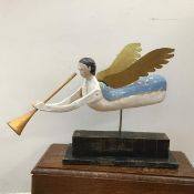 A naive American Folk Art style angel figure, the wooden carved body with metallic wings, holding