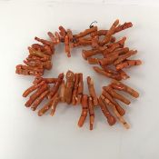 A pink coral necklace comprising a strand of multiple assorted fragments of coral (50cm)