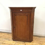 A George III oak and inlaid corner cabinet, the moulded projecting cornice above a plain frieze