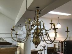 A brass ceiling pendant in the 17thc Dutch style, with twelve scrolling branches terminating in