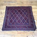 A hand knotted North West Persian rug, the madder and indigo field with ivory lattice design