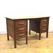 A 1920s oak desk, the rectangular top with chamfered edges above two banks of three drawers,