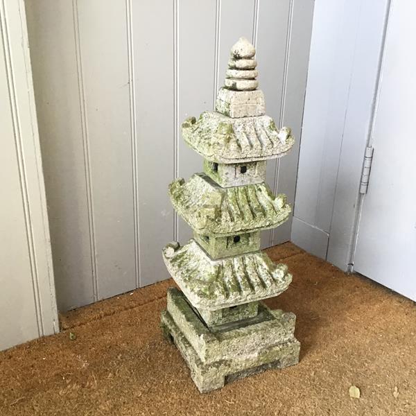 A composition stone garden pagoda with natural mossing and weathering, in five removable sections (