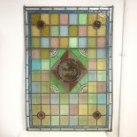 A stained leaded glass panel, c.1900 of chequerboard design with a central circular panel