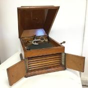 An HMV oak cased windup gramaphone, the moulded hinged lid opening to the HMV logo to base, with the