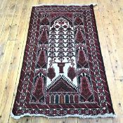 A hand knotted wool rug, of Caucasian design, the ivory field decorated with serrated motifs, within