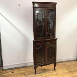 An Edwardian mahogany corner cabinet, the moulded cornice above an inlaid frieze, the astragal