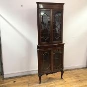 An Edwardian mahogany corner cabinet, the moulded cornice above an inlaid frieze, the astragal