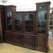 An Edwardian oak bookcase in six sections, the central two door bookshelf with arched glass