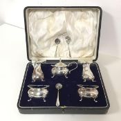 A 1920s Glasgow silver condiment set, comprising pepperettes, two salts and a mustard with spoon,