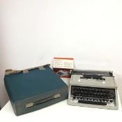 An Olivetti Dora typewriter with instruction pamphlet and travelling case (a/f) (9cm x 28cm x 34cm)