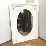 A modern wall mirror, the oval glass within a rectangular frame with moulded edge and foliate