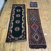 A hand knotted Afghan runner, the brown field decorated with four conjoined lozenges highlighted