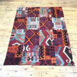 A patchwork banner incorporating panels of kelim rug, with various hooked and stylised flower