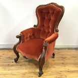 A Victorian rosewood button back armchair, c.1860, the arched frame enclosing a buttoned back and