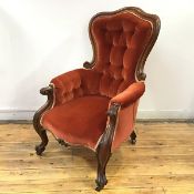 A Victorian rosewood button back armchair, c.1860, the arched frame enclosing a buttoned back and