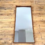 A 1960s Danish wall mirror, the rectangular mirror plate within an undulating frame, the back