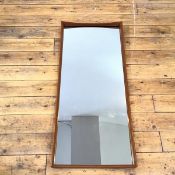 A 1960s Danish wall mirror, the rectangular mirror plate within an undulating frame, the back