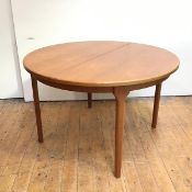 A teak extending dining table by Mackintosh, Kirkcaldy, the circular top enclosing a hinged