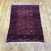 A hand woven Turkoman rug, the madder field with two rows of conjoined indigo and ivory gulls within