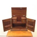 An Edwardian mahogany smoker's cabinet, the hinged top and front doors enclosing a pipe rack and