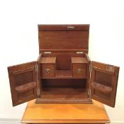 An Edwardian mahogany smoker's cabinet, the hinged top and front doors enclosing a pipe rack and