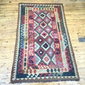 A hand knotted kelim rug, the field decorated with multiple bands enclosing serrated motifs, in
