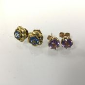 A pair of 9ct gold claw set amethyst stud earrings and a pair of yellow metal blue stone set