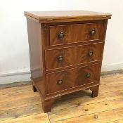 A reproduction mahogany batchelor's chest, the hinged top with moulded edge over three drawers,