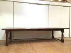 A large oak refectory style table, the eight plank top with cleats to each end above an arcaded